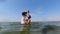 A boy jumps into sea water from his father\\\'s arms. Slowmotion. Family vacation at sea, water games