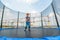 The boy jumps on a trampoline in an amusement park, performing various stunts