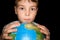 Boy keeps in hands over globe of world isolated