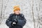 Boy keeps in hands snowball in wood in winter