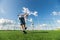 Boy kicking a penalty at goal playing with his father on a green grass.