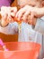 Boy kid baking cake. Child breaking egg into a bowl. Kitchen.