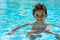 Boy kid child eight years old inside swimming pool portrait happy fun bright day