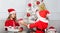 Boy kid dressed as santa with white artificial beard and red hat give gift box to girl. Kids celebrate christmas with