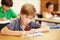 Boy kid, school classroom and writing test with focus, concentration and thinking for education goals. Male child, book