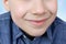 Boy, kid smiles with his mouth closed, closeup of a childâ€™s mouth, concept of child skin care, emotional development of