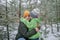 Boy kisses mom with happiness that the first long-awaited snow has fallen, family walks in forest