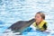 Boy kissing dolphin in pool