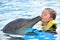 Boy kissing dolphin in pool