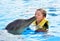 Boy kissing dolphin in pool