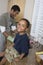 Boy At Kitchen Counter With Father Washing Dishes