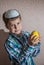 The boy in knitted kippah is holding etrog