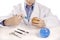 Boy in lab coat injecting blue liquid into apple