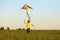 The boy launches a kite. Summer day. Sunny.The boy in a yellow t-shirt with a kite