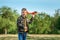 The boy launches a toy airplane against the backdrop of greenery. The concept of dreams, choice of profession, pilot, childhood.