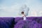 Boy in lavender field with white balloons, sunny day,