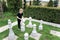 Boy on the lawn with a huge chessboard stands next to a piece and thinks about the next move