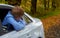 Boy leaned out of the window of a parked white car