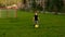 Boy learning to play football on a green field
