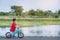 The boy is learning to ride a bicycle with a special bike for children by the lake.