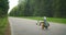 Boy learns to ride a scooter in a city park. Toddler boy riding scooter.