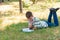 The boy lies in the park on the grass and is studying in nature, education and science, the book is lying on the grass