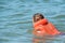 Boy in life jacket learn to swim. Safe sea vacation with children