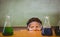 Boy looking at conical flasks in classroom