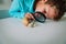 Boy looking at giant snail through magnifying glass