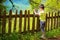 Boy looking in map next to the village fence on a fantastic sunny summer day