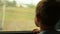 Boy looking out the window of moving train