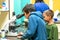 The boy looks through a microscope in a laboratory with curiosity.  Children came on an excursion to the clinic