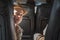 Boy looks out from behind chair in cabin passenger plane. Portrait of a smiling child 8-10 years in the light from window.