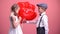 Boy in love giving cute girl heart-shaped balloons, Valentines day surprise