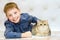 Boy lying down and smiling. Kitten of the British Shorthair Blue