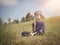 Boy Making Dandelion Wish on a Green Hill