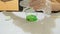 A boy making green slime at home, DIY project, chemistry experiment, he pours the ingredients into a container and mixes