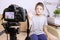 A boy, male child video blogger recording vlog or podcast, streaming online. Blurred camera on tripod in front