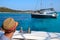 Boy or man looking at a sails boat in the north of Sardinia - Archipelago La Maddalena