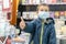 Boy in medical mask at bookstore. young boy chooses books in a bookshop. boy wear a protective mask In a bookstore. Concept of