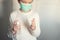 Boy in a medical mask disinfects his hands with a spray