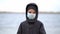 Boy medical mask on his face during quarantine stands on beach during the second wave quarantine coronavirus COVID-19