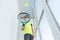 Boy in medical mask holds tennis racket and ball and plays tennis on apartment balcony