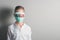 Boy in a medical mask with red inscription MEASLES on his face on bright background