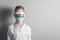 Boy in a medical mask with red inscription RUBELLA on his face on bright background