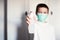 Boy in a medical mask sprays a disinfector