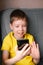 Boy with a mobile phone speaks by video calling at home.  the scoolboy  communicates via video link. Video chatting at home.