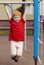 Boy on monkey bars. Little boy hanging on gym activity center of school playground. Outdoor activity for kids. Sport