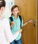 Boy and mother staying near flat entrance and talking
