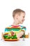 Boy moves back plate with tasteless broccoli, portrait on white background